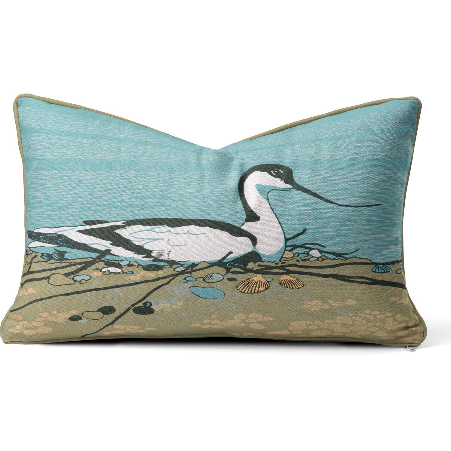 A rectangular cushion with a large avocet sitting on the sand on it.